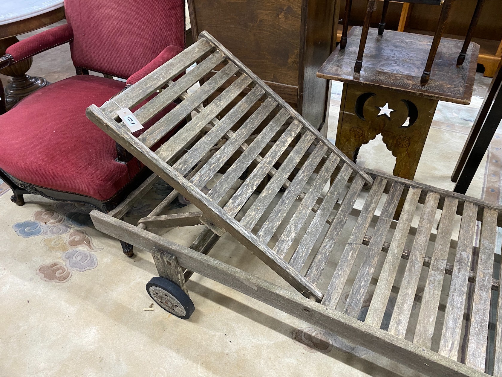 A weathered teak garden lounger on wheels, length 198cm